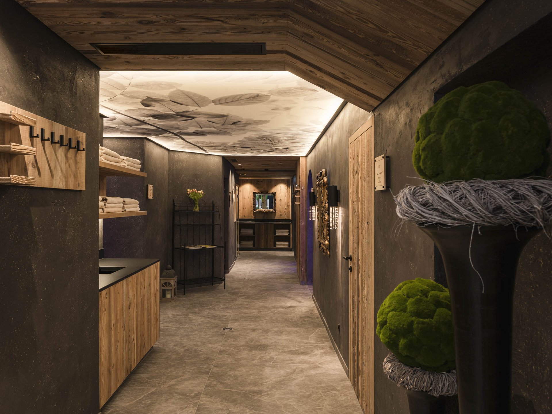 Beleuchteter Flur mit natürlicher Dekoration und Holzmöbeln in modernem Design