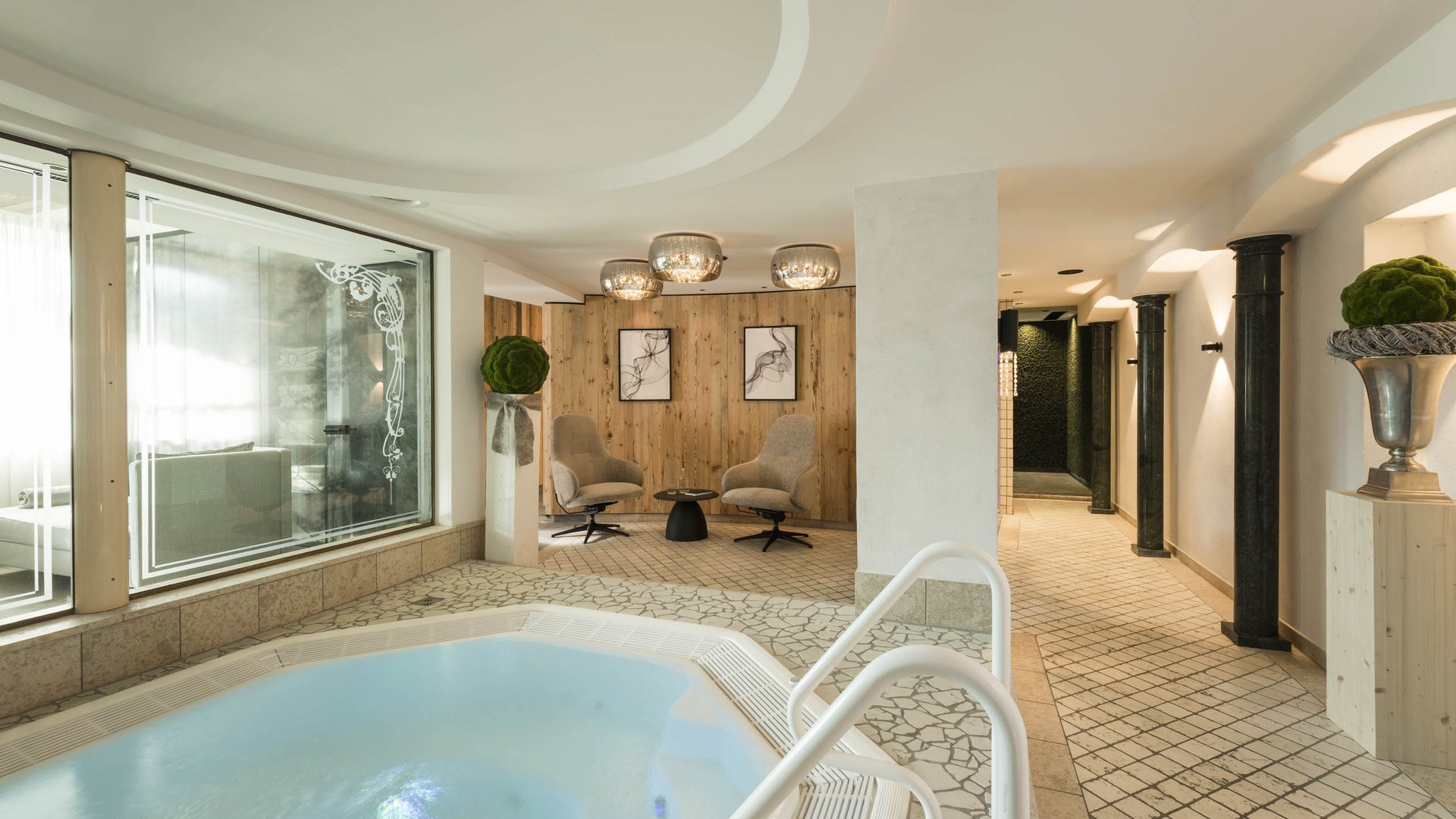 Indoor spa area with hot tub, seating area, and modern lighting fixtures