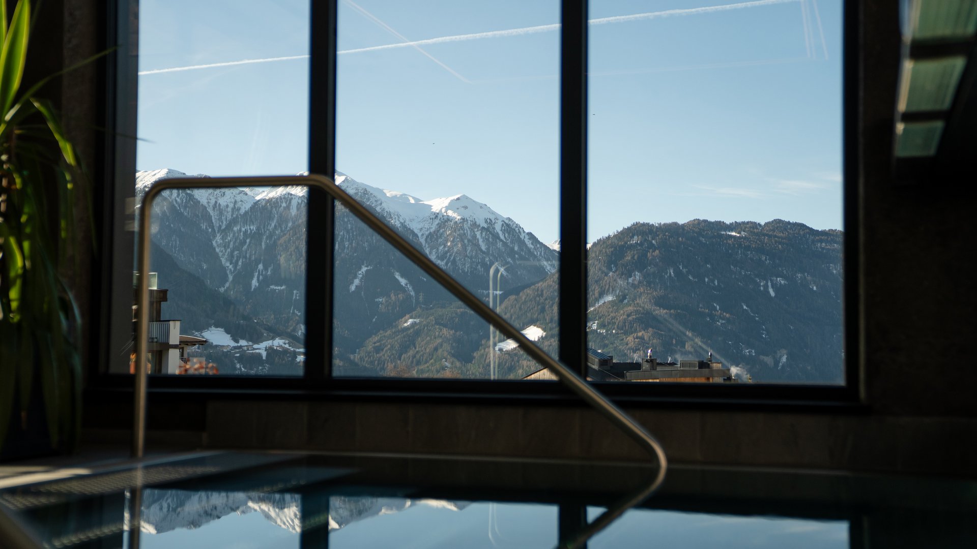 Snowy mountain landscape seen through a window with handrail