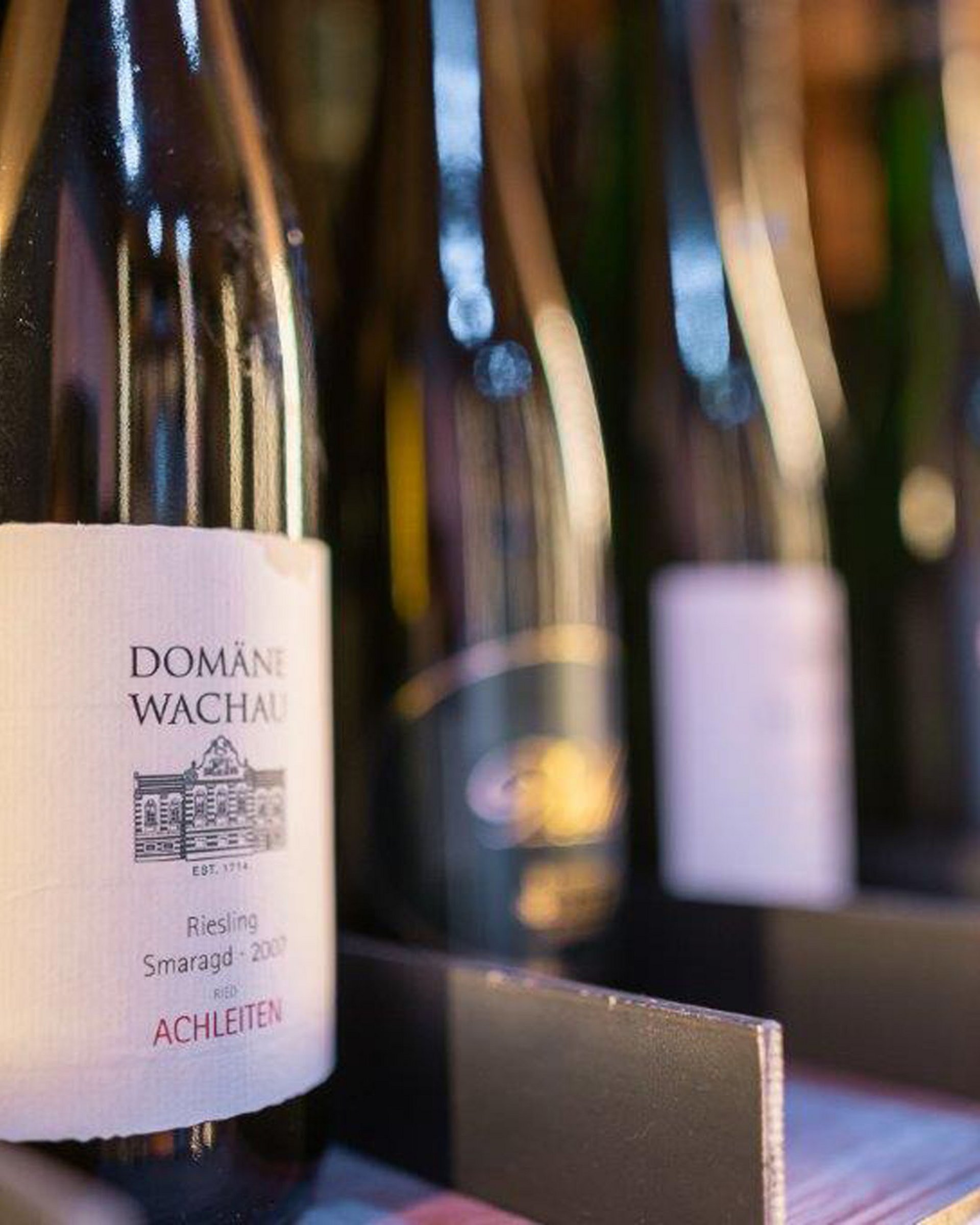 Wine bottles on a shelf, focus on Domäne Wachau Riesling Smaragd 2009