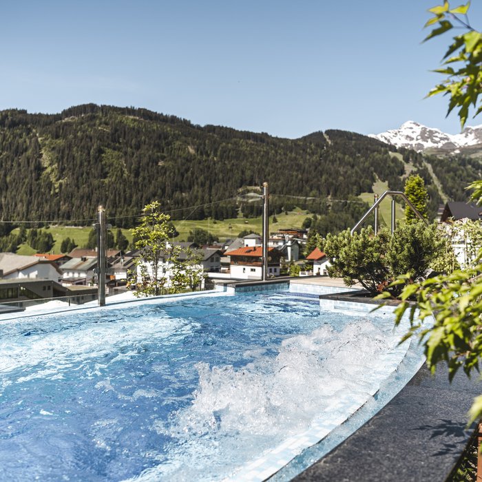 Whirlpool mit Bergblick im sonnigen Dorf im Sommer