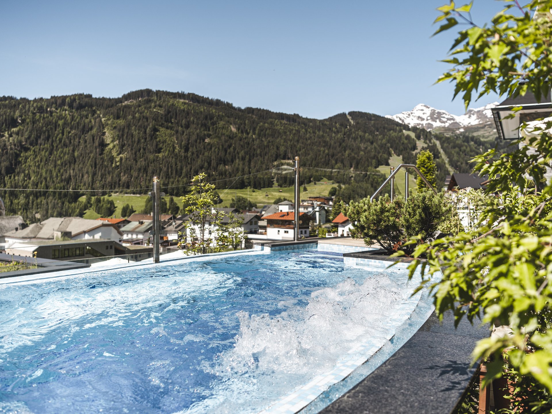 Hot tub with mountain view in sunny village during summer