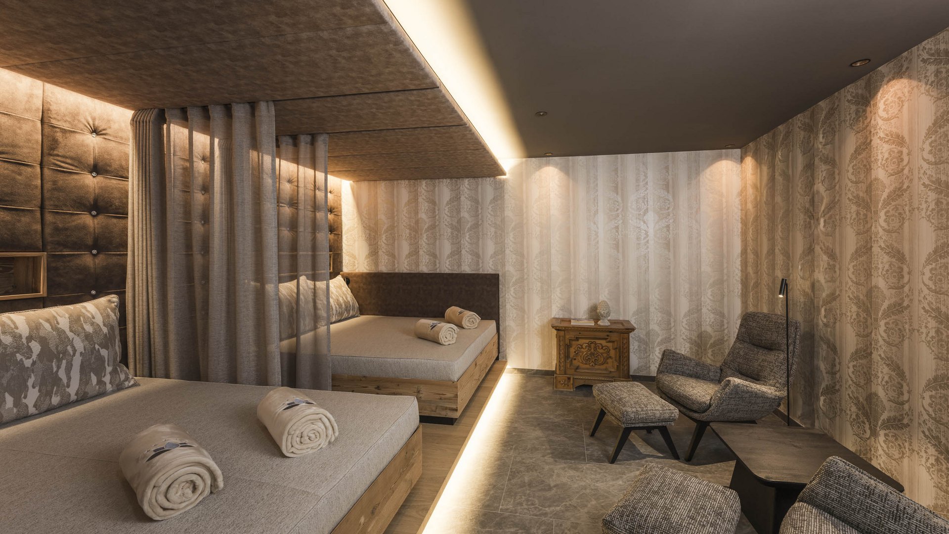 Modern spa room with two loungers, stools, and soft lighting