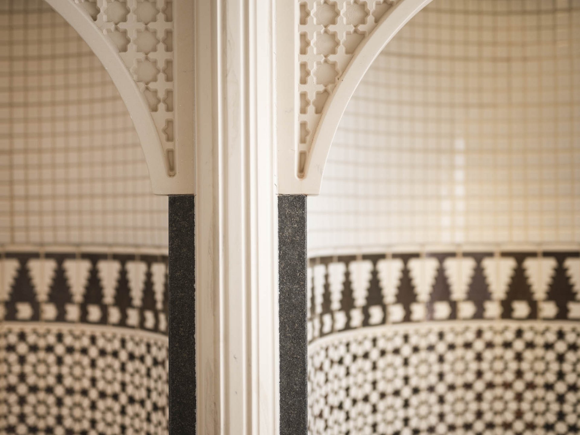 Close-up of a decorative arch and column with geometric patterned tiles