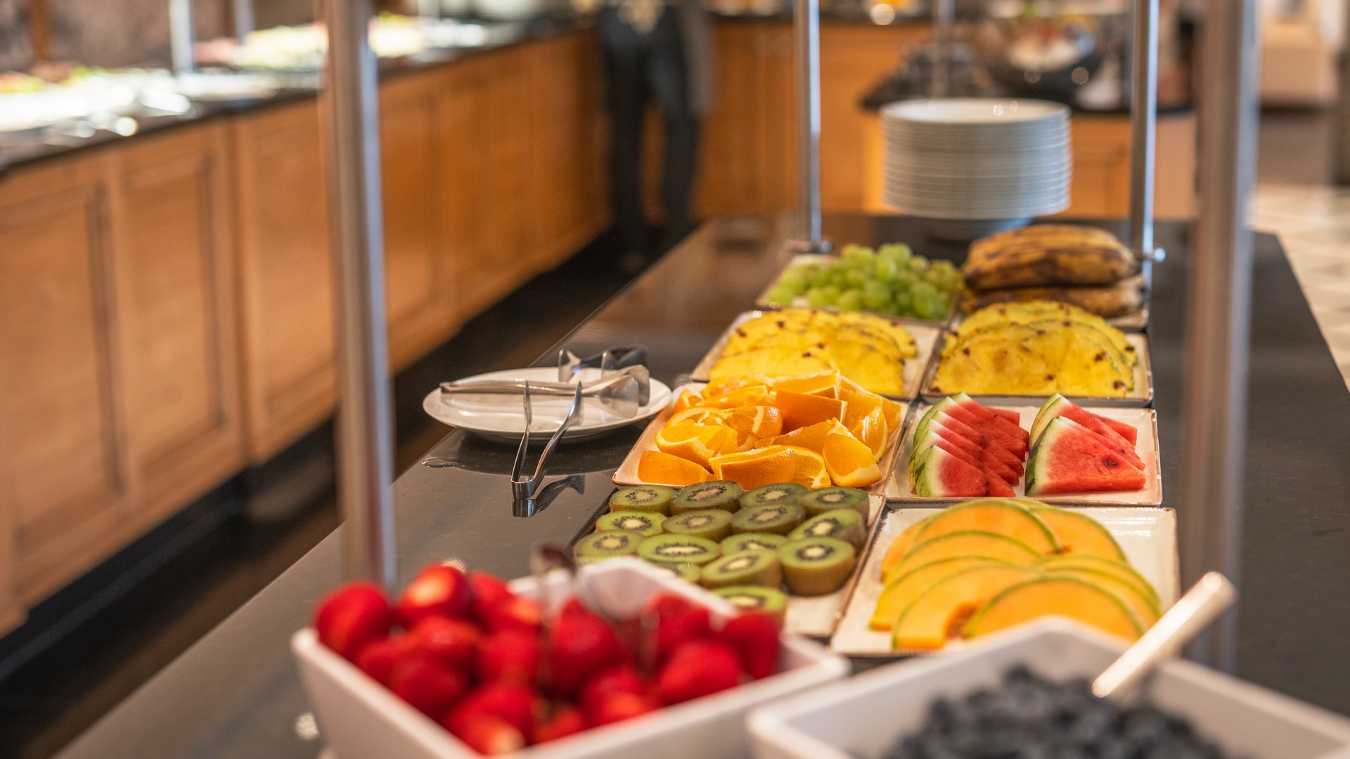 Buffettisch mit geschnittenem Obst und Schalen mit Beeren im Restaurant
