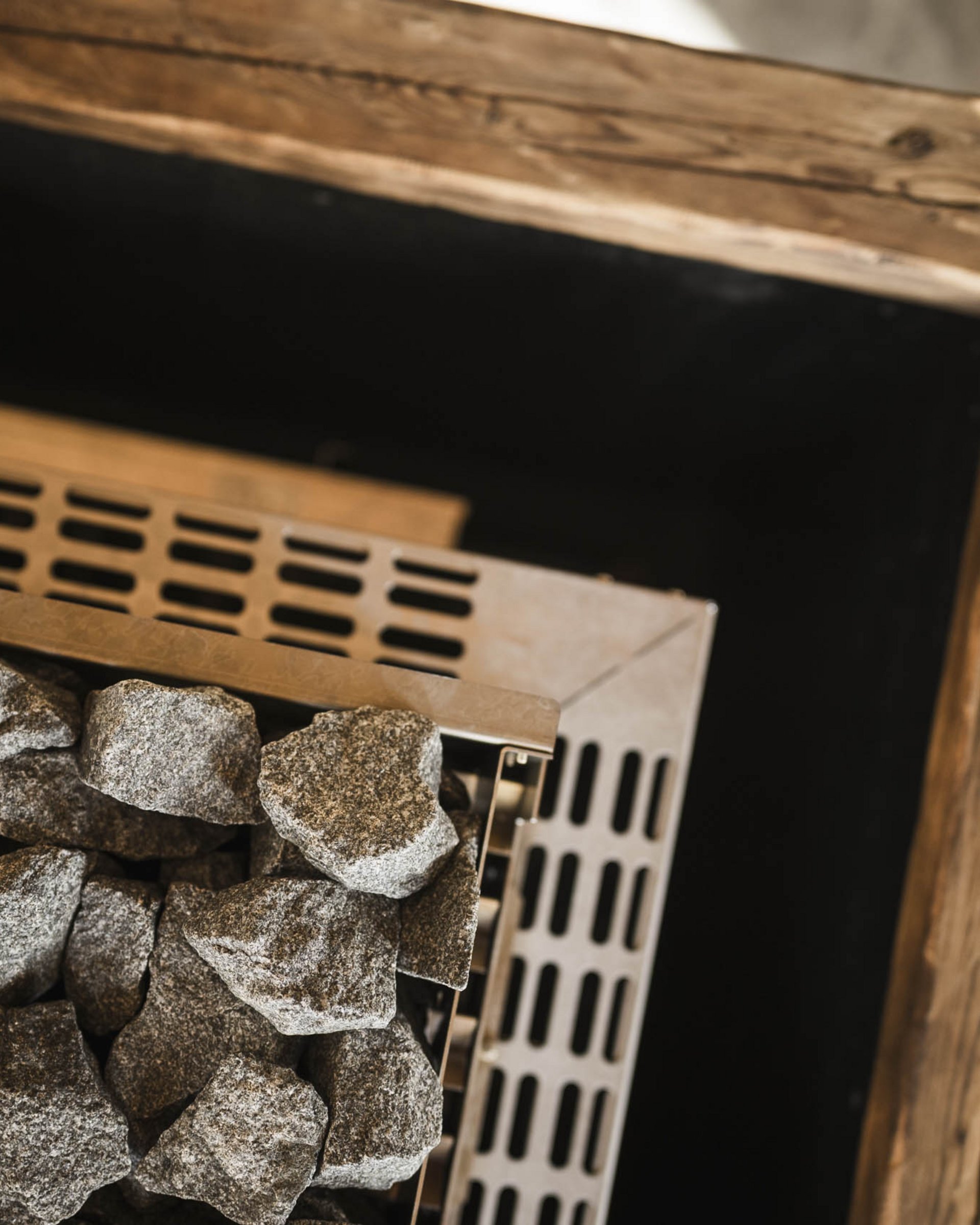 Sauna heater with hot stones inside a wooden frame