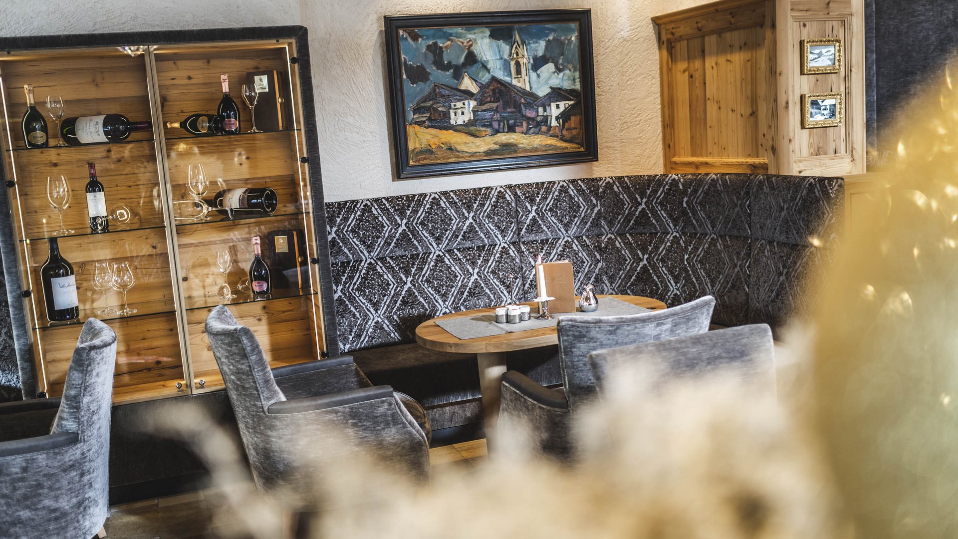 Gemütliche Sitzecke in Restaurant mit Weinregal und Gemälde an der Wand