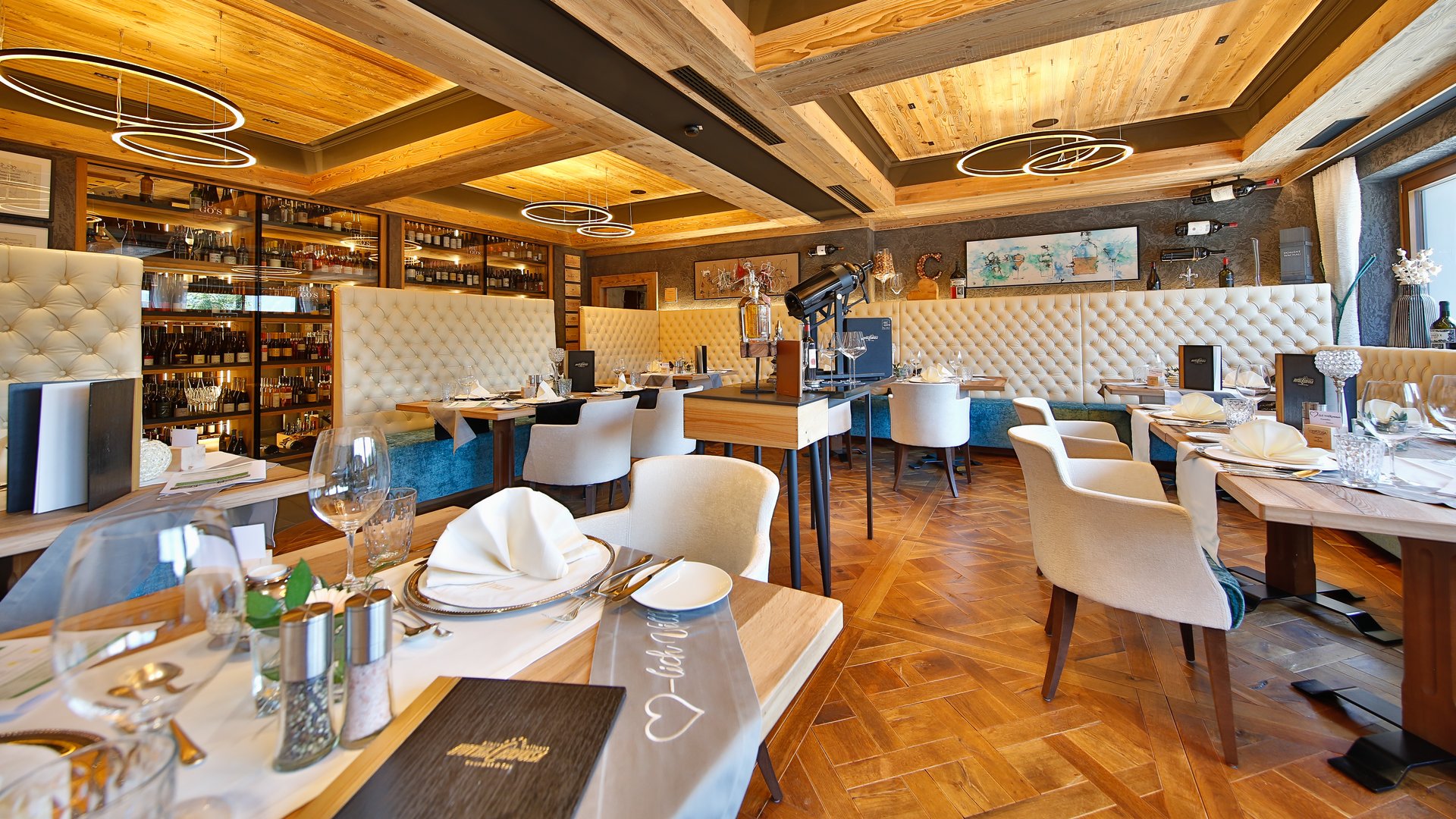 Elegantes Restaurant mit Holzboden, weißen Stühlen und Weinregal an der Wand