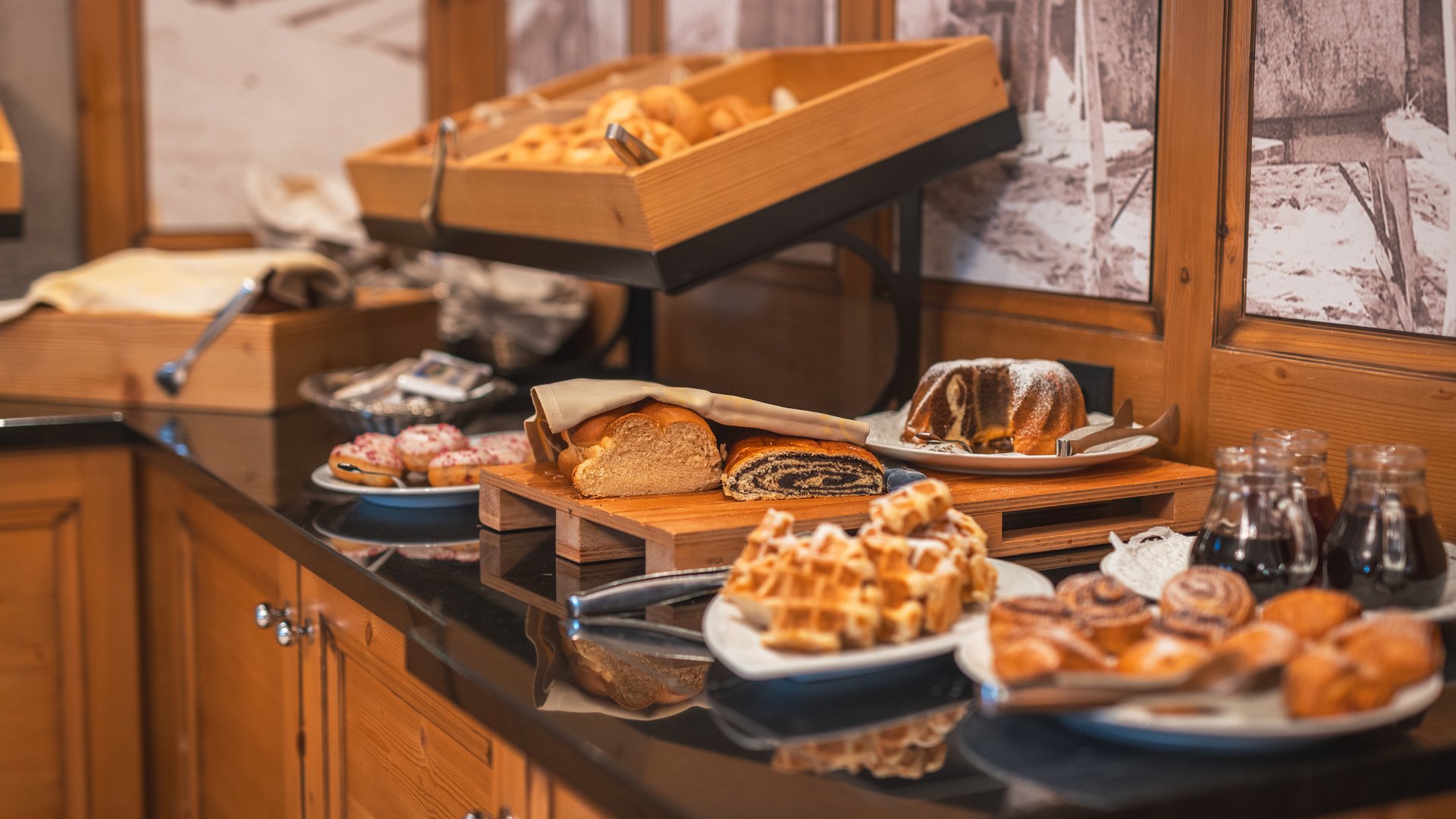 Buffet mit verschiedenen Backwaren und Süßgebäck auf schwarzer Arbeitsplatte