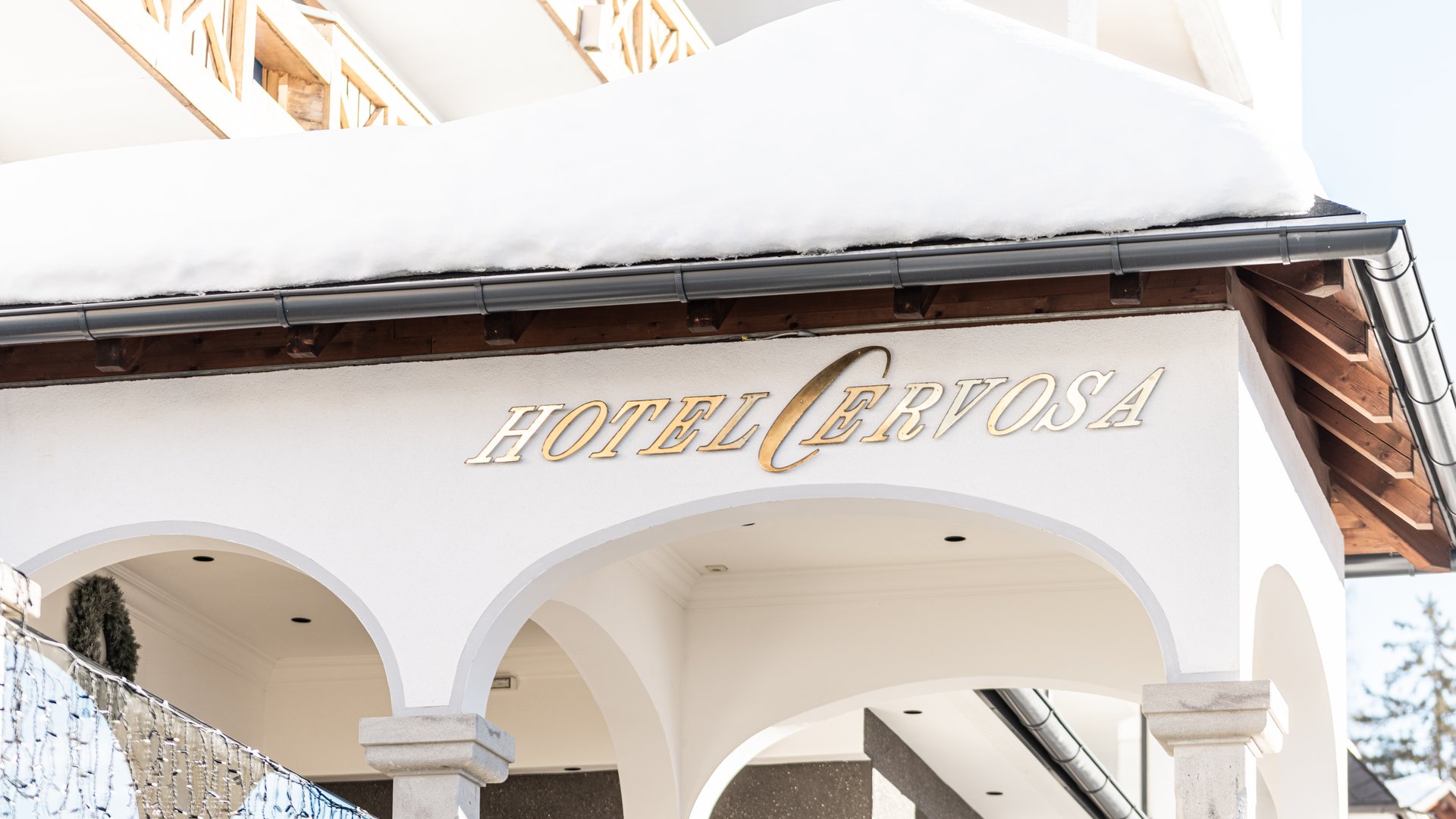Hotel Cervosa mit schneebedecktem Dach und weißen Bögen
