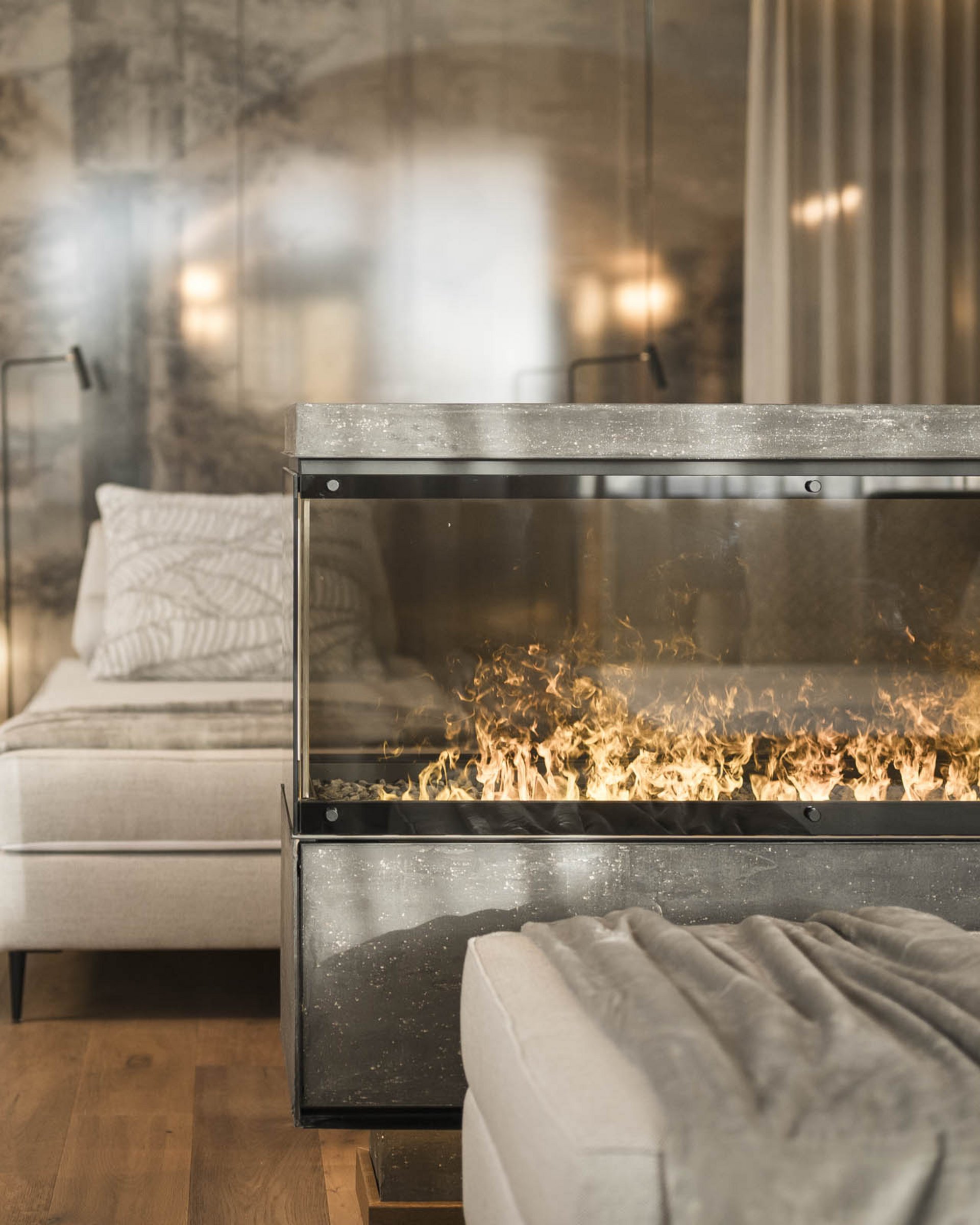 Modern room with two beds, electric fireplace, and gray blanket