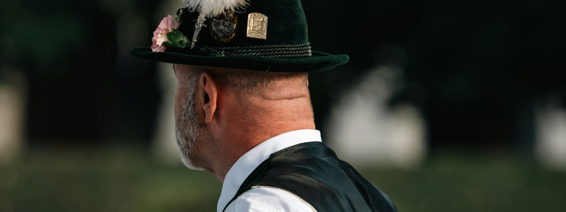 Lokale Bräuche rund ums Paznauntal Mann im Profil mit schwarzem Hut und großer weißer Feder, weißem Hemd und dunkler Weste