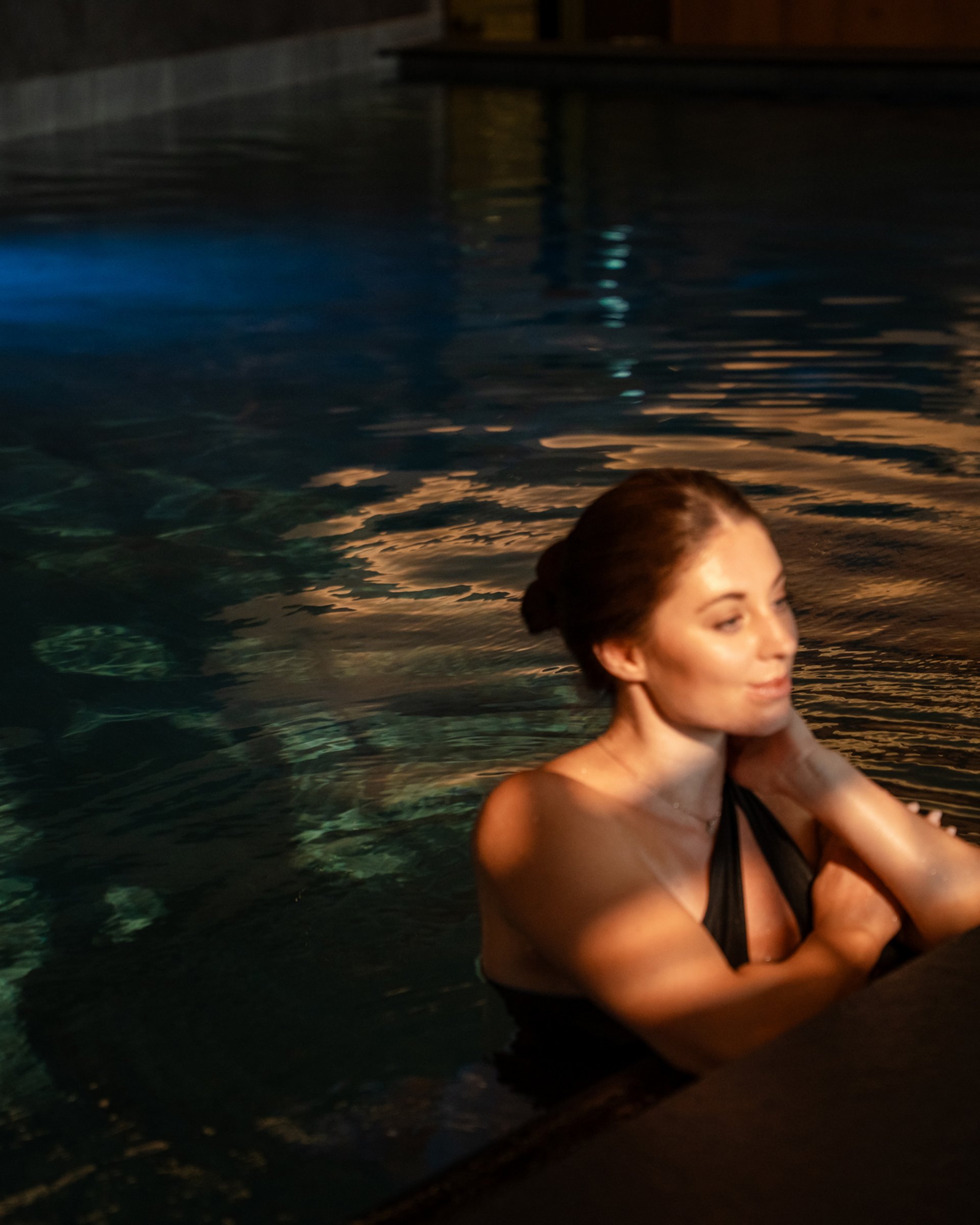 Bathing bliss at our hotel with pool in Serfaus Woman relaxing in swimming pool with dim lighting