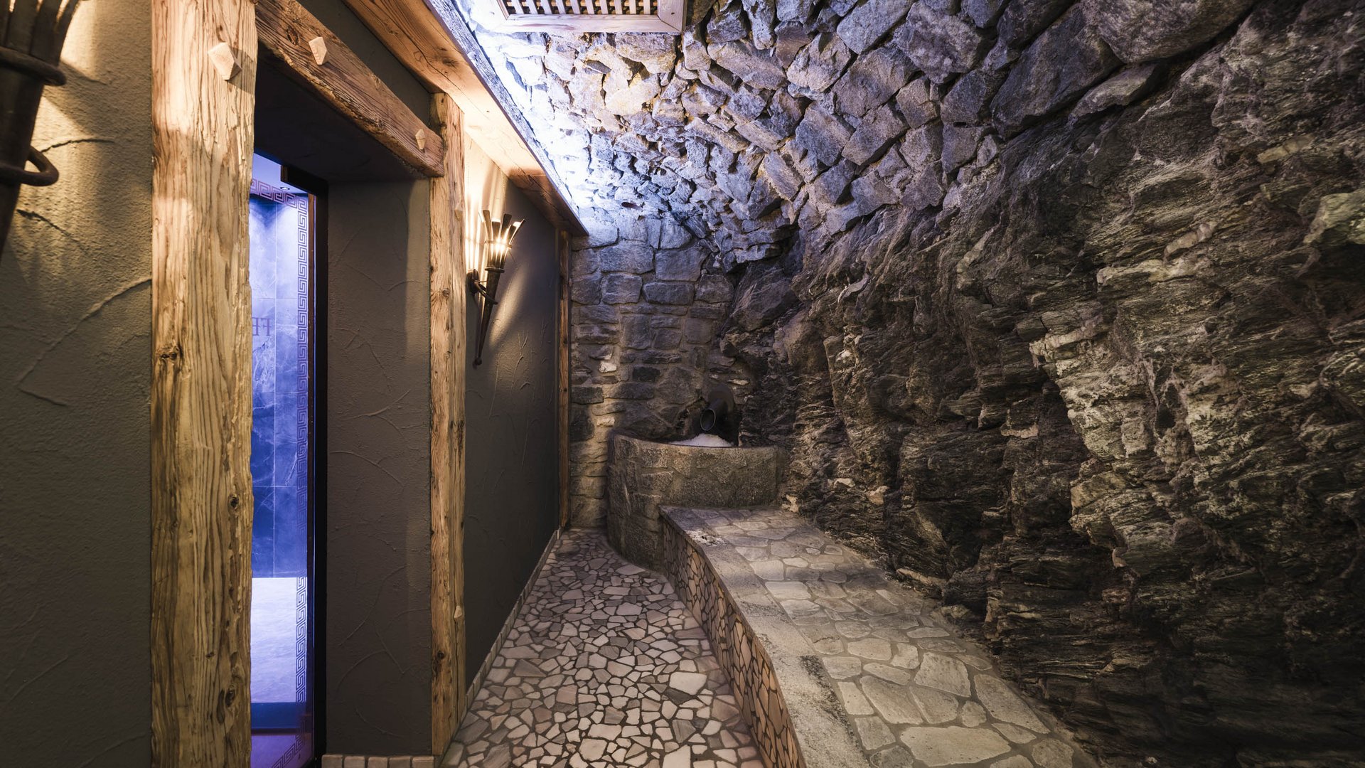 Masonry relaxation room with natural stone walls and wooden door frame
