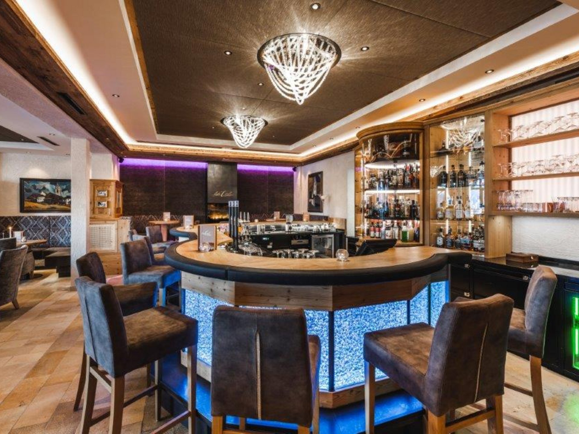 Moderne Bar mit beleuchtetem Tresen und gemütlichen Stühlen