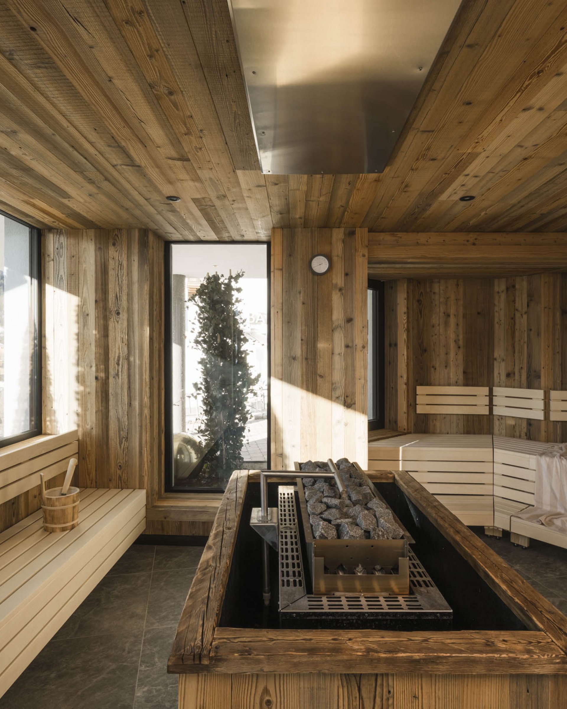 Moderne Sauna mit hellem Holzinterieur und Panoramafenster mit Bergblick