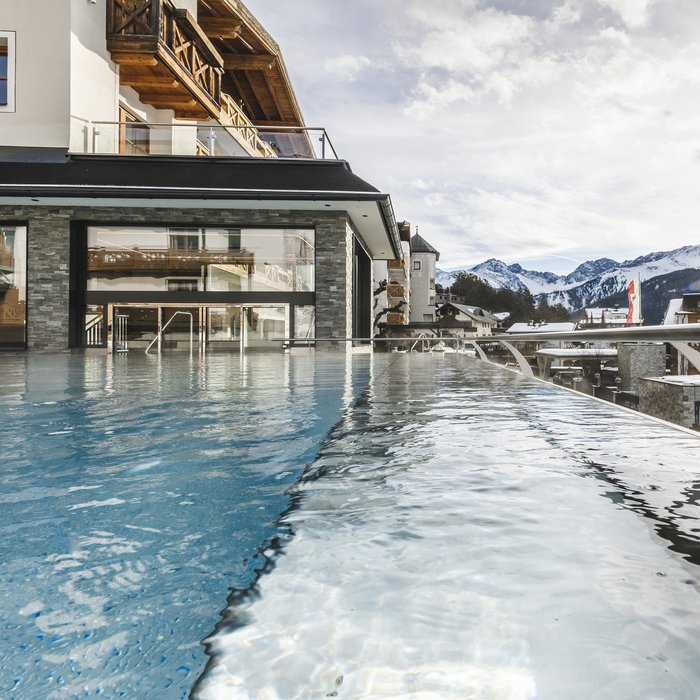 Infinity-Pool mit Bergblick und Sonnenlicht an einem modernen Hotel