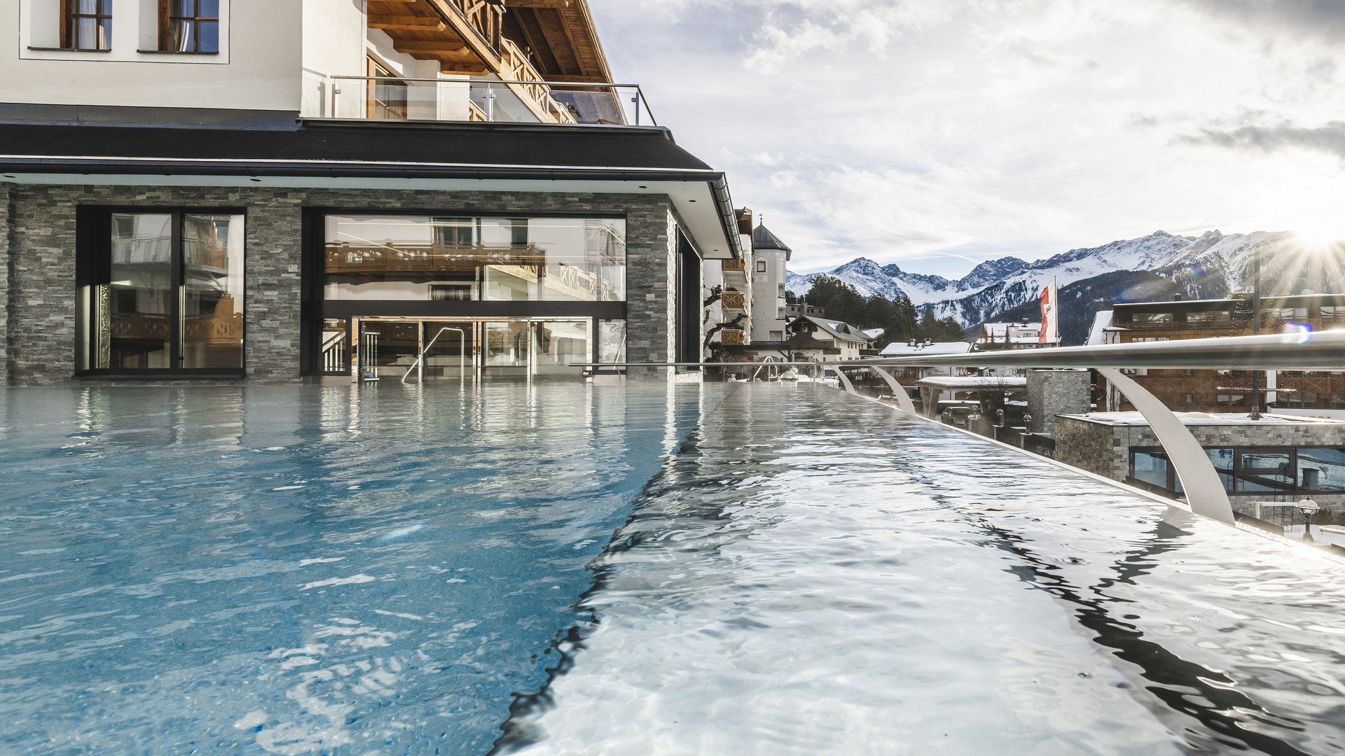 Infinity-Pool mit Bergblick und Sonnenlicht an einem modernen Hotel