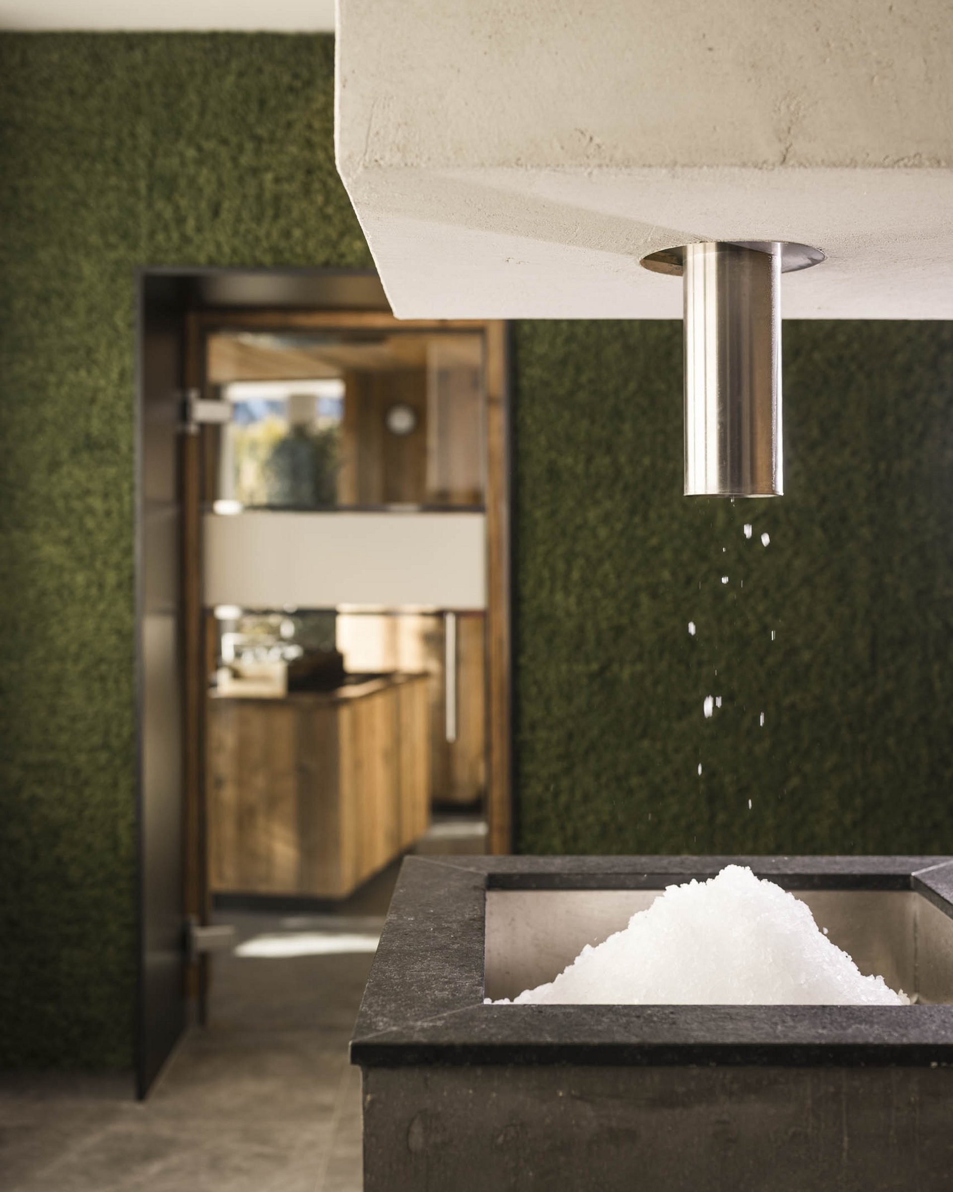 Eis fällt aus einem Ausguss in einen modernen Behälter im Innenraum